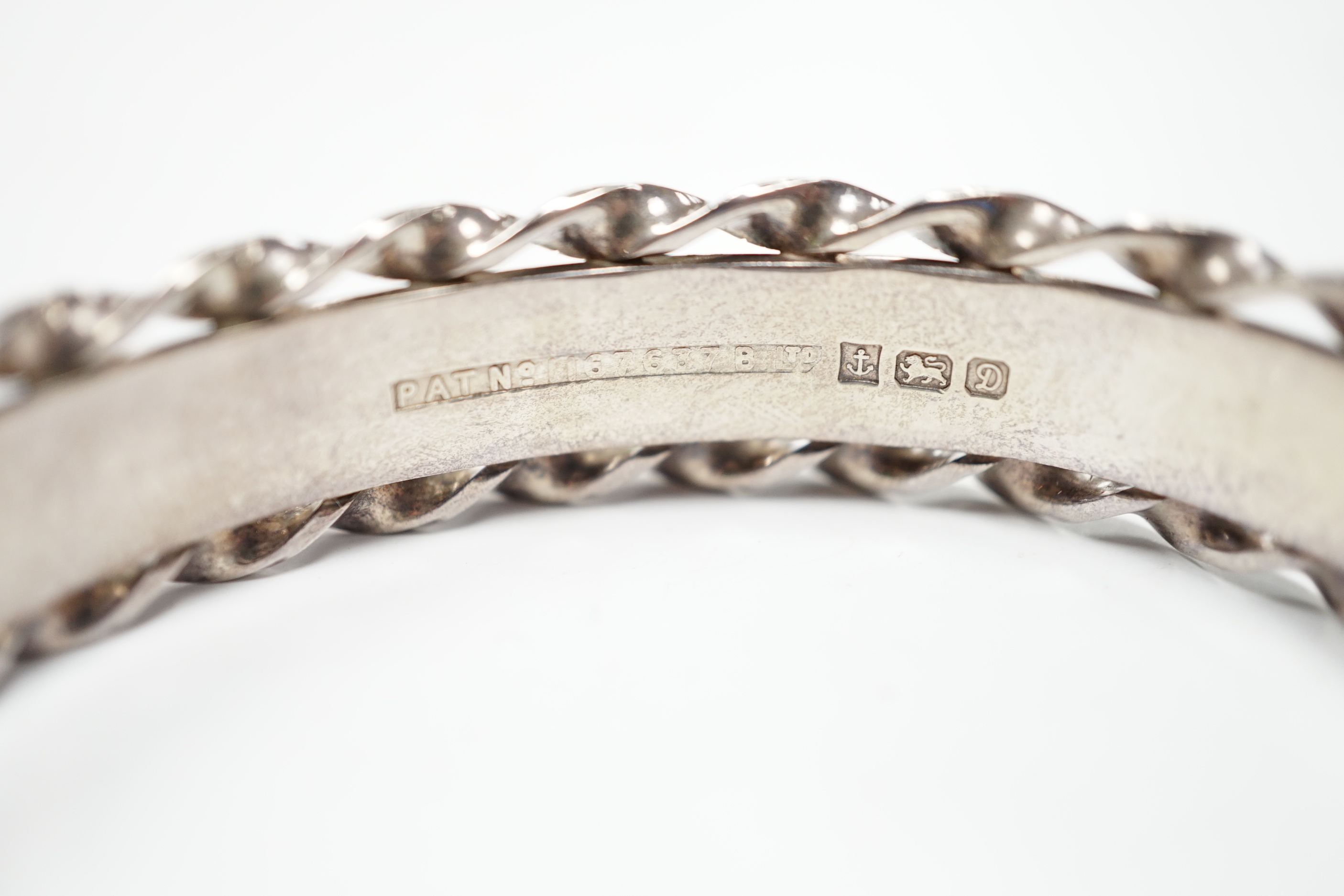 An Elizabeth II bright cut engraved silver hinged bangle, with spiral borders, Birmingham, 1978.